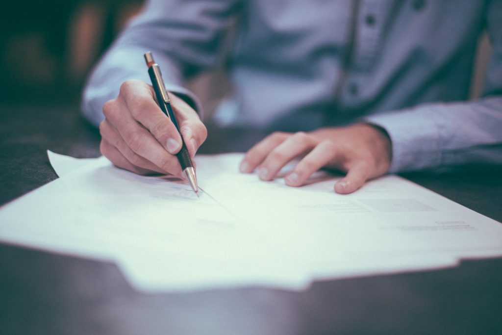 Man signing papers.